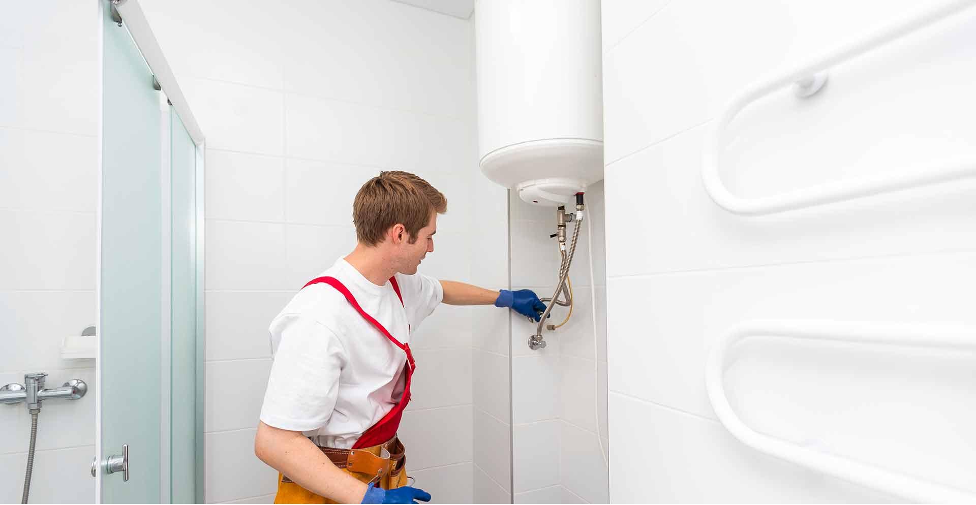 Technicien PrestaGaz installant un chauffe-eau